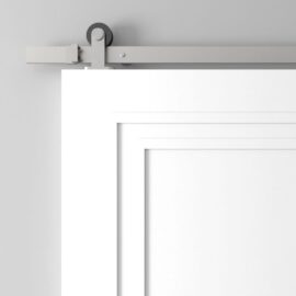 A detailed view of the Atelier Barn Door on a grey wall, highlighting its metal sliding mechanism at the top.