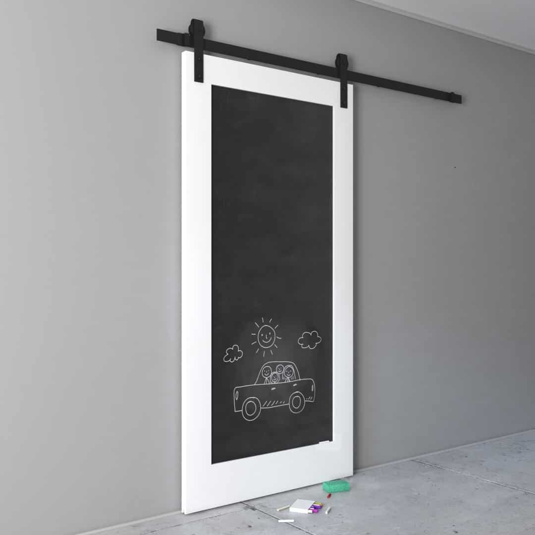 CHALKBOARD-DOOR-3.jpg A Chalkboard Barn Door featuring a chalk drawing of a car, a smiling sun, and clouds on the lower half, with pieces of chalk and an eraser lying on the floor.