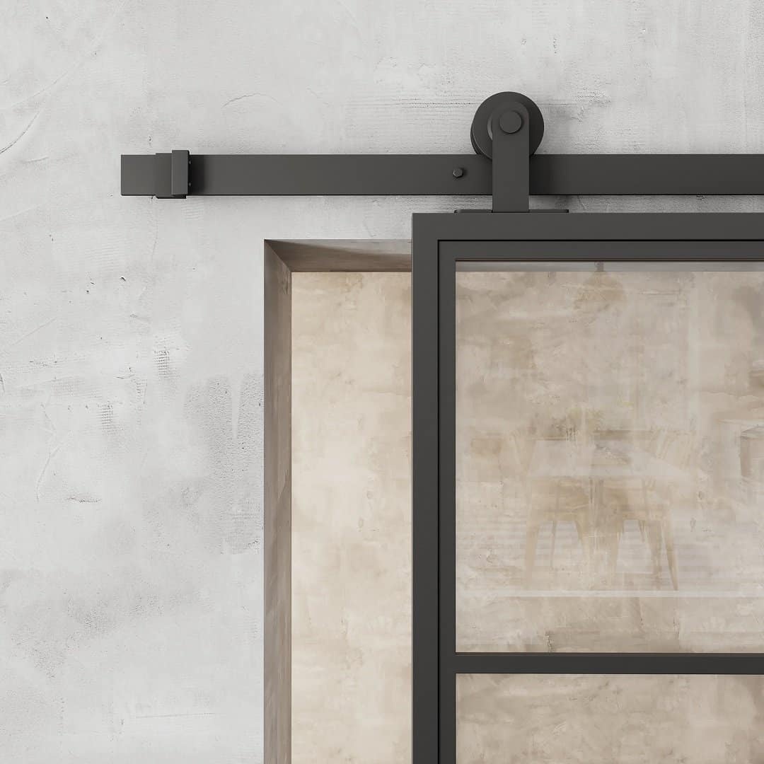 FC-4-PANEL-2.jpg Close-up of the French Casement 4-Panel Barn Door featuring a sleek black metal frame, mounted on a wall with a visible black sliding mechanism. The background wall has a textured, light-colored finish.