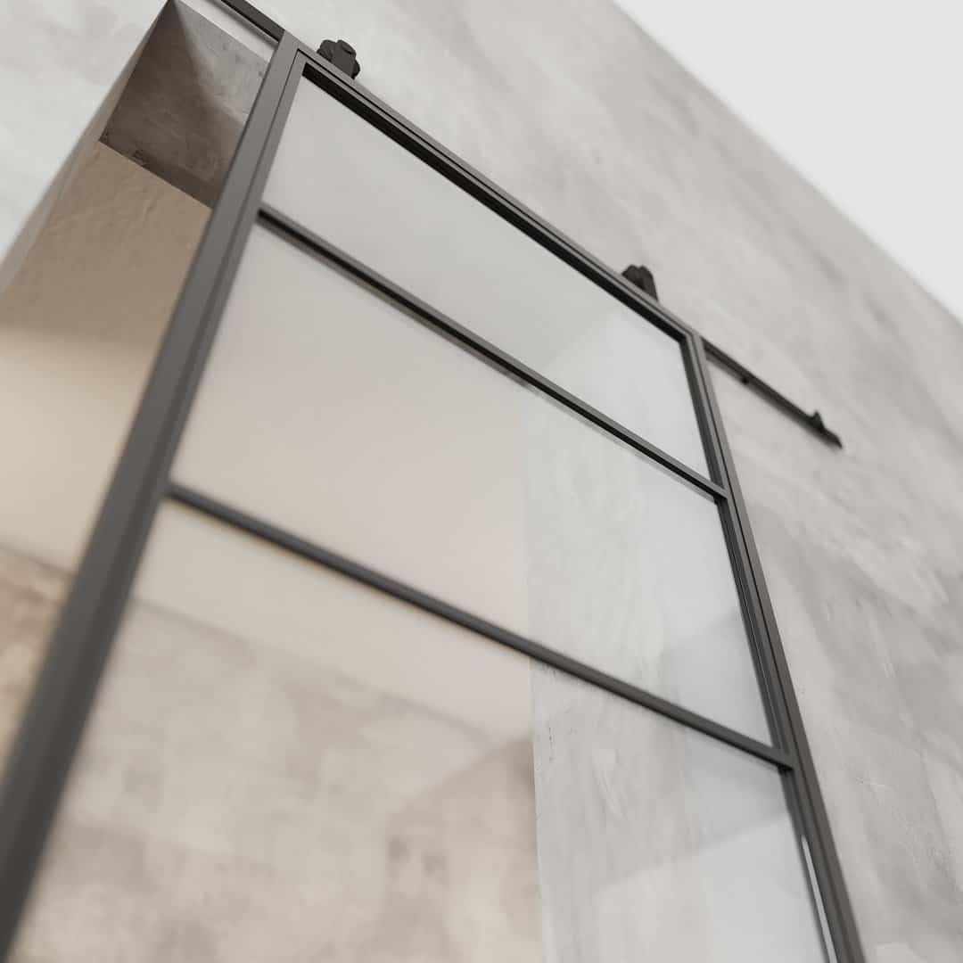 Close-up of a French Casement 4-Panel Barn Door with a metal frame installed on a concrete wall. The door is slightly open, and the image is taken from a low angle.