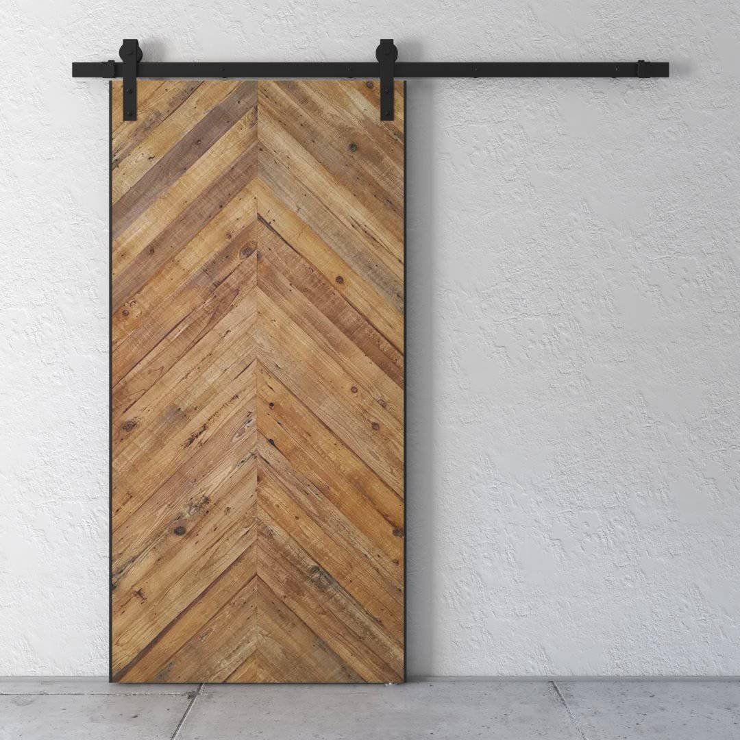 A Natural Herringbone Barn Door installed on a white wall.