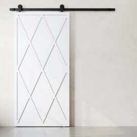 A Lynx Barn Door featuring a geometric diamond pattern against a plain light-colored wall.
