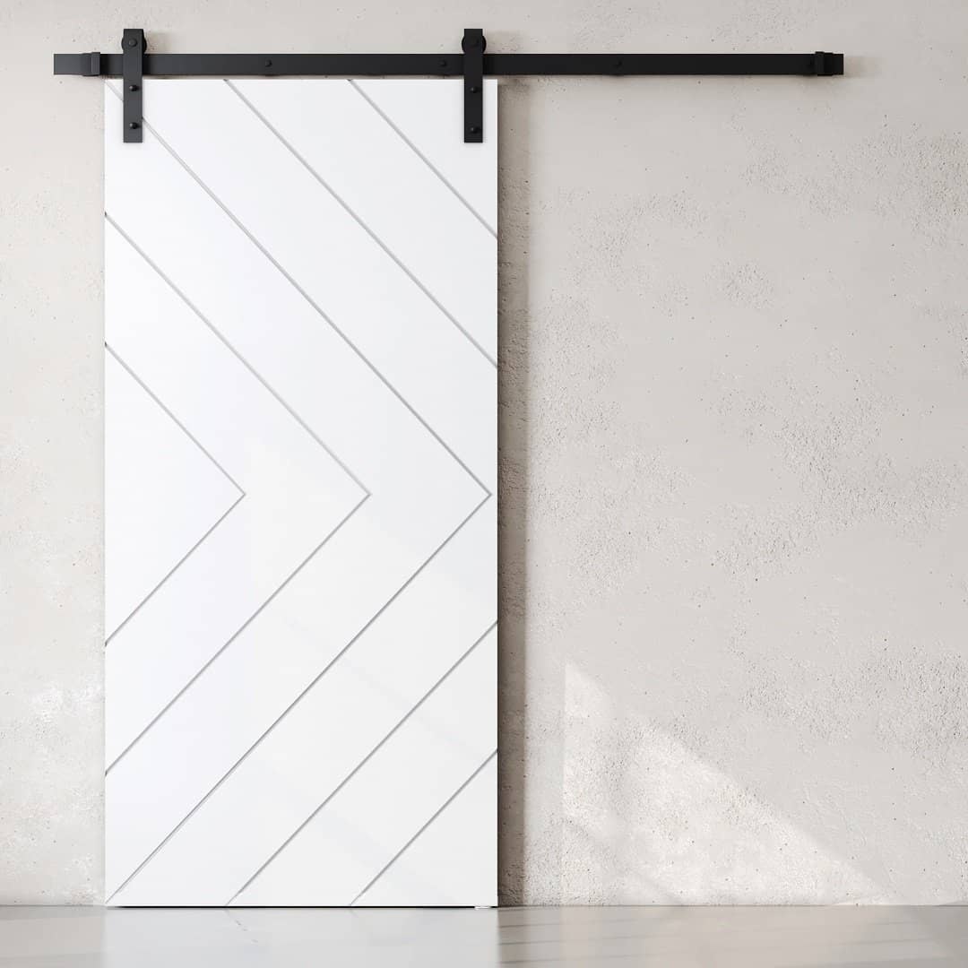 The Prestige Barn Door, featuring a white finish with diagonal lines, is mounted on a black metal track against a light-colored wall.