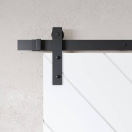 Close-up view of the Prestige Barn Door track system installed on a white door with diagonal paneling against a light gray wall.