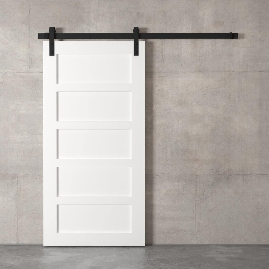 A 5-Panel Barn Door, featuring five rectangular sections in white, is mounted on a black sliding barn door track against a plain, gray concrete wall.