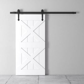 A white double barn door with a diagonal cross pattern is mounted on a black sliding rail against a light grey wall.