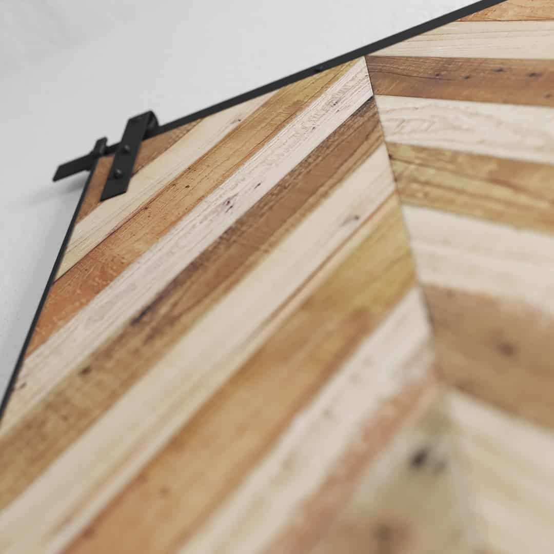 Urban-Woodcraft-Herringbone-Barn-Door-Bohemian-2.jpg Close-up of the Bohemian Herringbone Barn Door featuring a diagonal herringbone pattern and a black metal sliding mechanism on top.