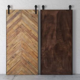 The Natural Herringbone Barn Door set features two wooden sliding doors suspended from sleek black metal tracks. The left door boasts a stylish chevron pattern, while the right door presents a smooth, dark wood finish, all perfectly contrasted against a textured white wall.