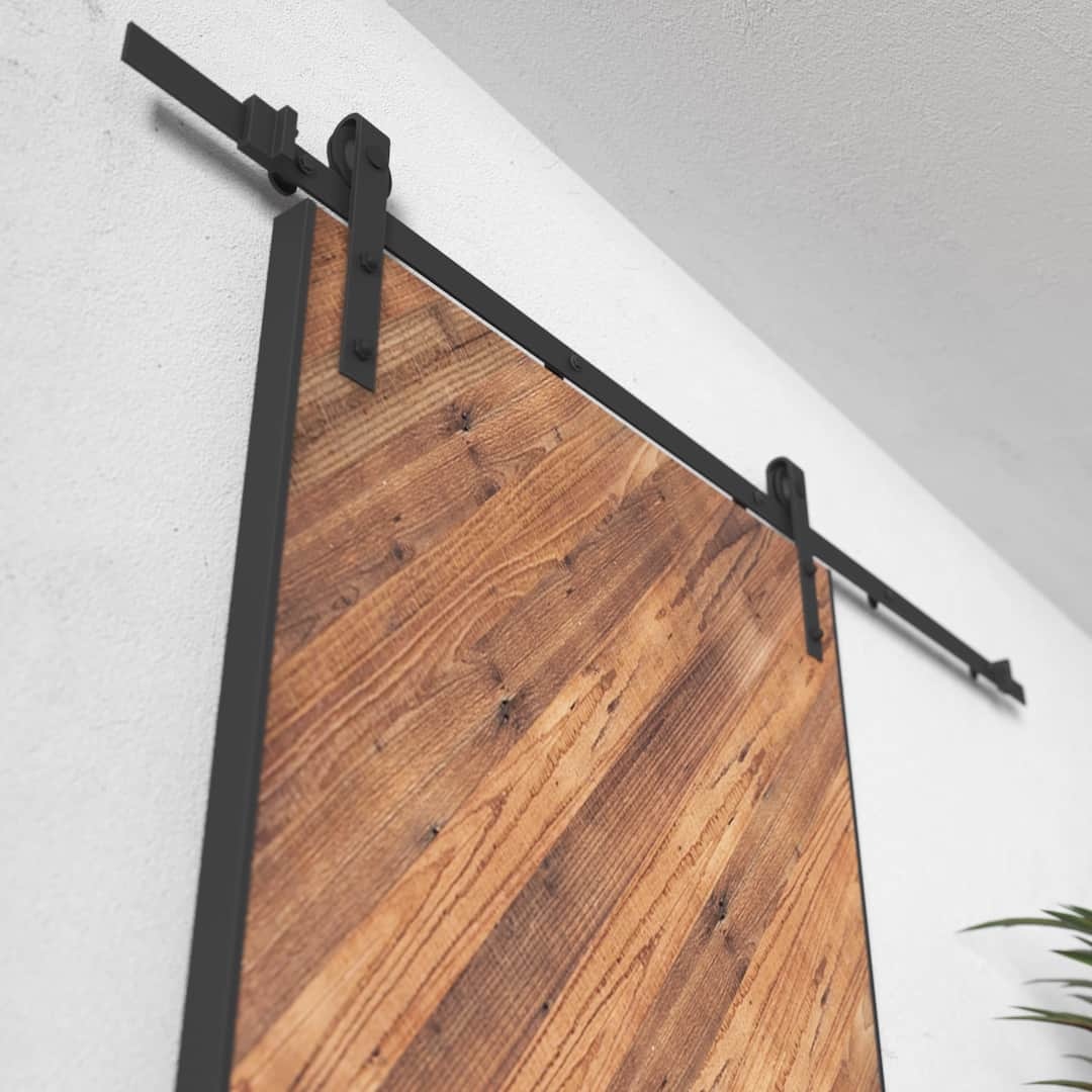 Urban-Woodcraft-Lucas-40in-Reclaimed-Wood-Arrow-Barn-Door-3.jpg Close-up of the Lucas Reclaimed Wood Arrow Barn Door mounted on a black metal track system attached to a white wall.