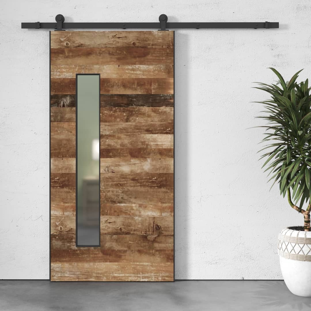 A Maison Reclaimed Wood - Frosted Glass Door, mounted on a black metal track, is positioned next to a potted plant against a white wall.