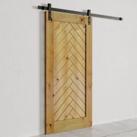 The Nuvo Barn Door, featuring a chevron pattern design, stands partially open against a white wall. It is mounted on a black metal rail.