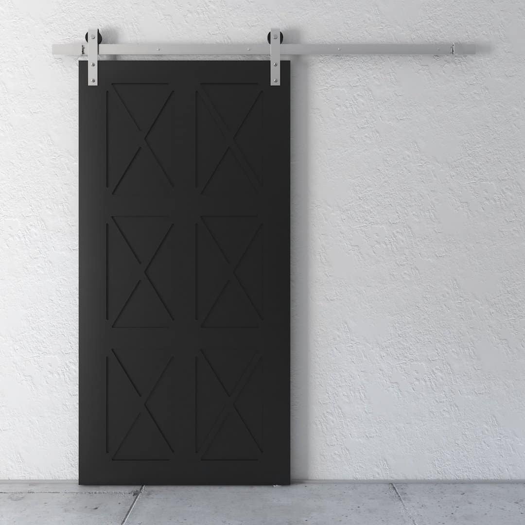 The Oxford Barn Door, featuring a black finish and an X-design panel, stands out against a white textured wall. The silver track and hardware are prominently visible at the top.